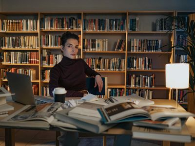 Student studying with many books and laptop